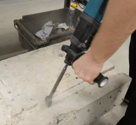 Ouvrier-creuse-saignée-beton-avec-perforateur-sans-fil-makita